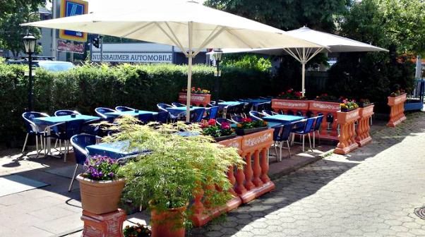 Die neue Sommerterasse mit Sonnenschirmen neben Alte Kastanienb�ume